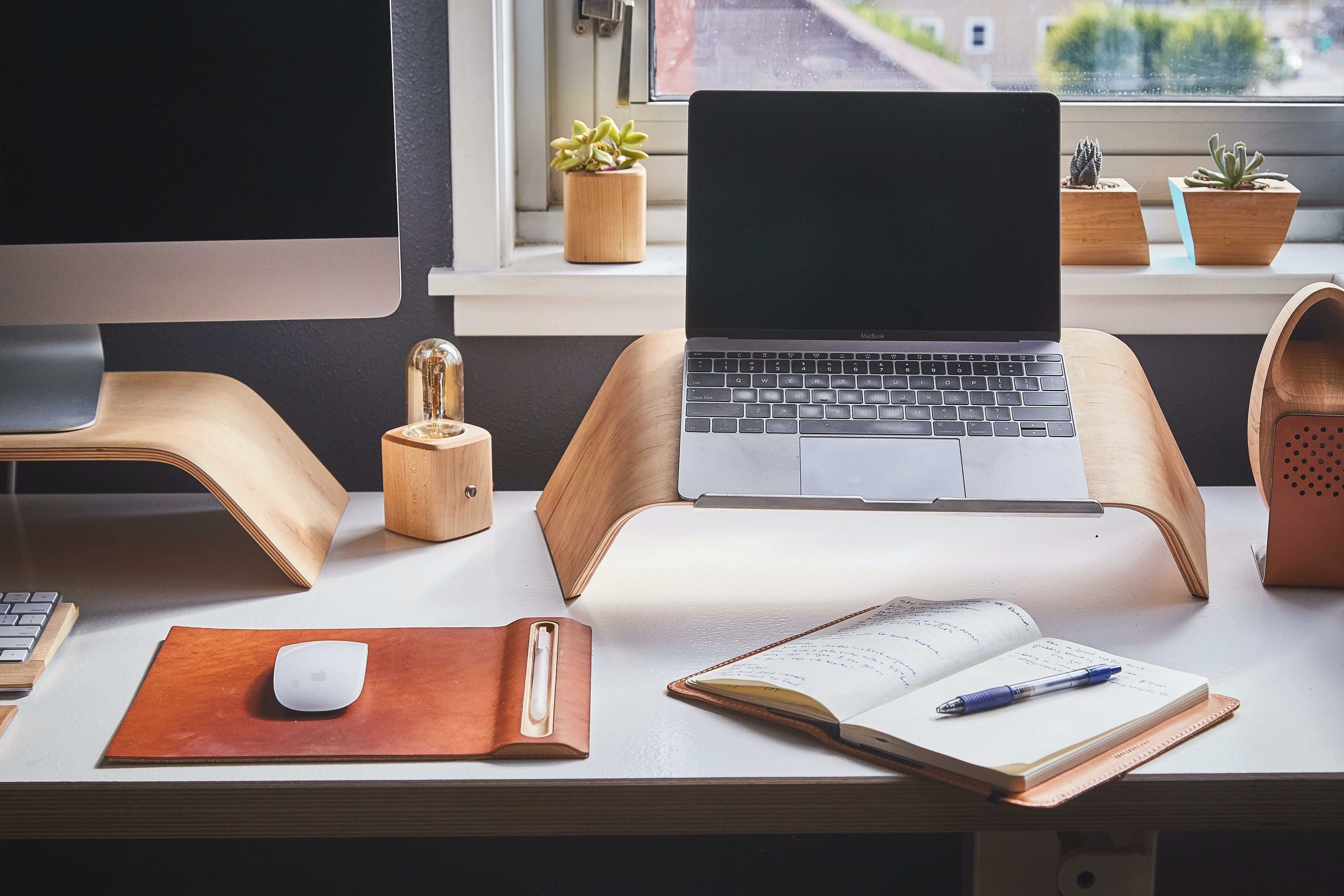 MacBook sur un support en bois sur un bureau