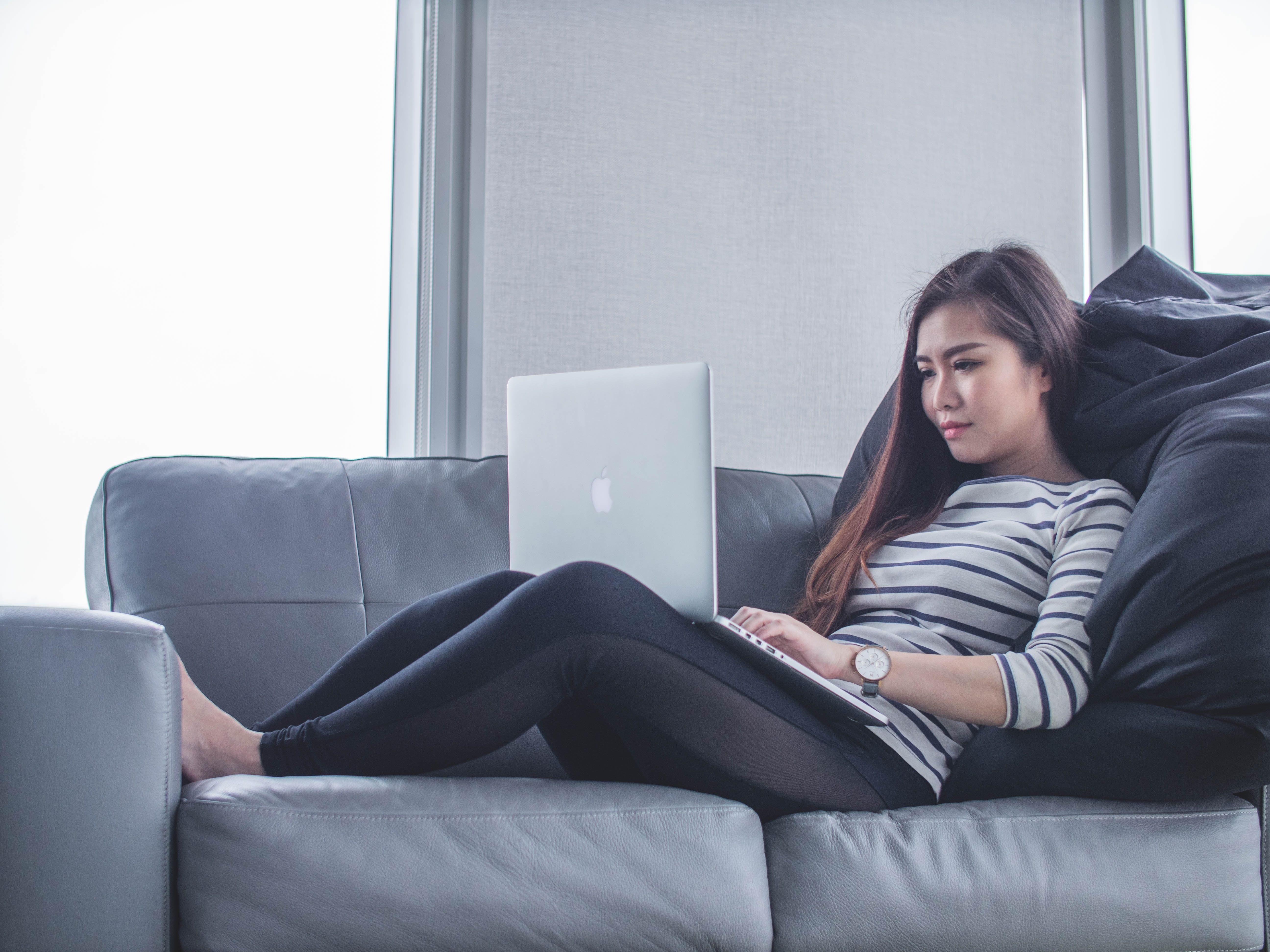 Photo d'une personne utilisant un MacBook en position assise