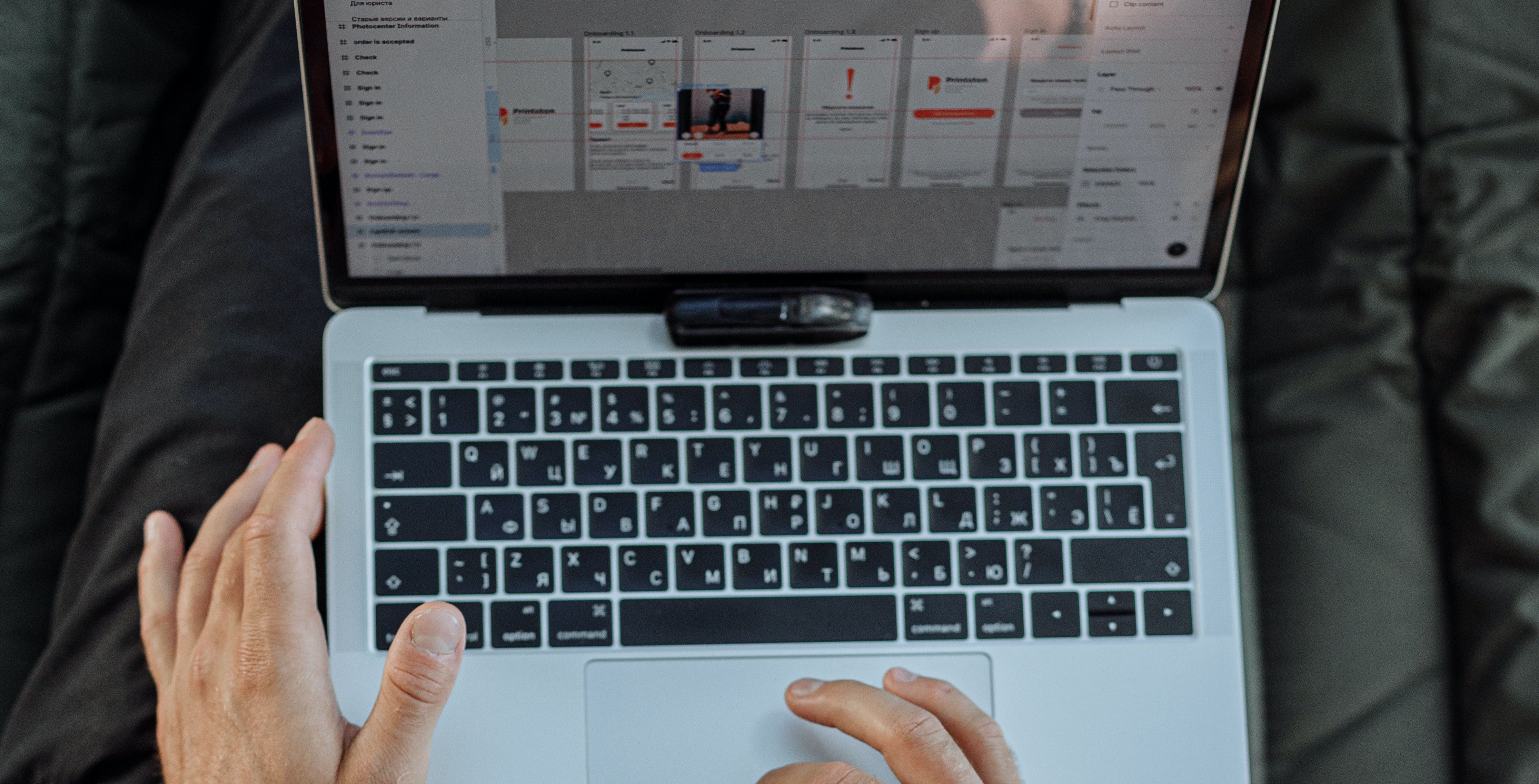 Une personne utilise un MacBook et fait glisser un élément sur la page via son trackpad