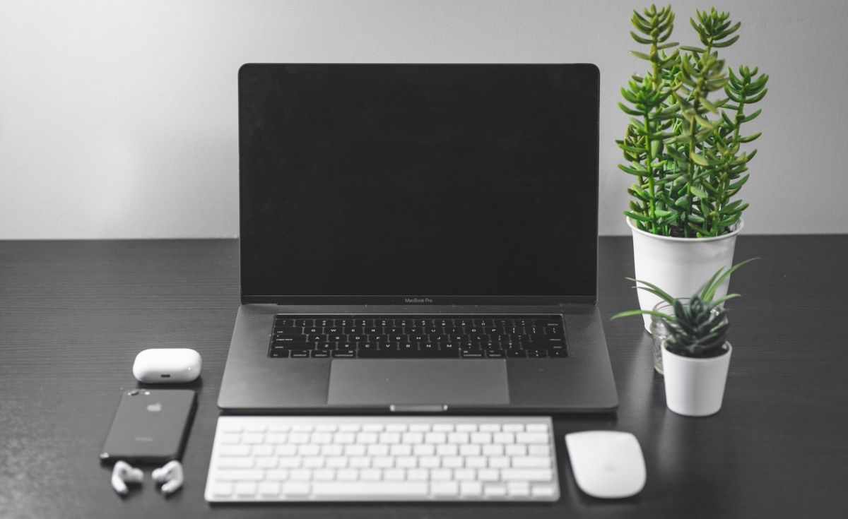 Un MacBook, un Magic Keyboard, une Magic Mouse, un iPhone et des AirPods.